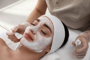 Young woman during face peeling procedure in salon