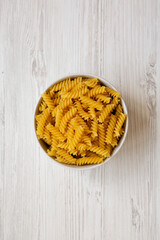 Uncooked Yellow Organic Rotini Pasta, overhead view. Flat lay, top view, from above.