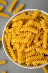 Uncooked Yellow Organic Rotini Pasta, top view. Flat lay, overhead, from above.