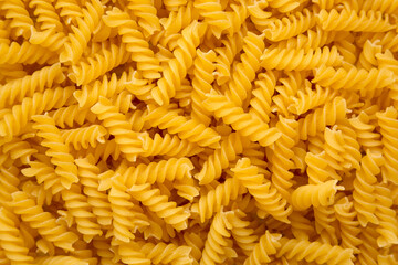 Uncooked Yellow Organic Rotini Pasta, view from above. Flat lay, top view, overhead. Closeup.