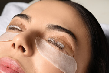 Young woman undergoing eyelash lamination, closeup. Professional service