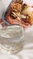 a glass of water with flowers on a beautiful background