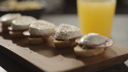 Fototapeta na wymiar small canapes with salami and mozzarella on baguette slices with pesto