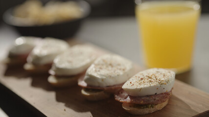small canapes with salami and mozzarella on baguette slices with pesto