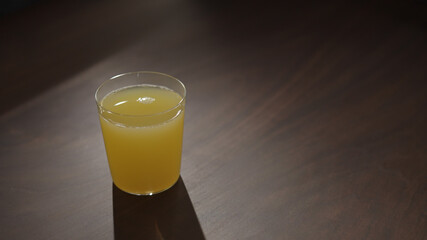 orange juice in glass on walnut wood table