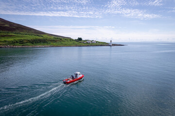 Obraz premium A Red Passenger and Cargo Ferry Visits an Island