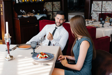 A young beautiful couple is having lunch in a fine restaurant. Customer service in the catering.