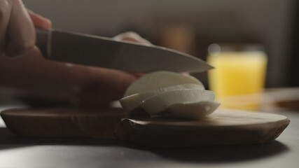 man slicing mozzarella on olive wood board