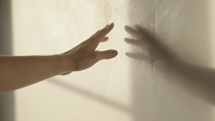 man playing with sunlight indoor next to wall