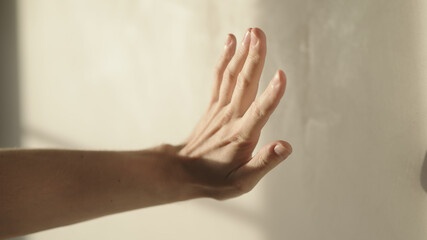 man playing with sunlight indoor next to wall