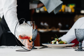 An exquisite salad of seafood, tuna and black caviar in a beautiful burning with fire serving on...