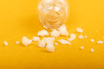 crystal mephedrone designer drugs, bath salt on yellow background. - obrazy, fototapety, plakaty