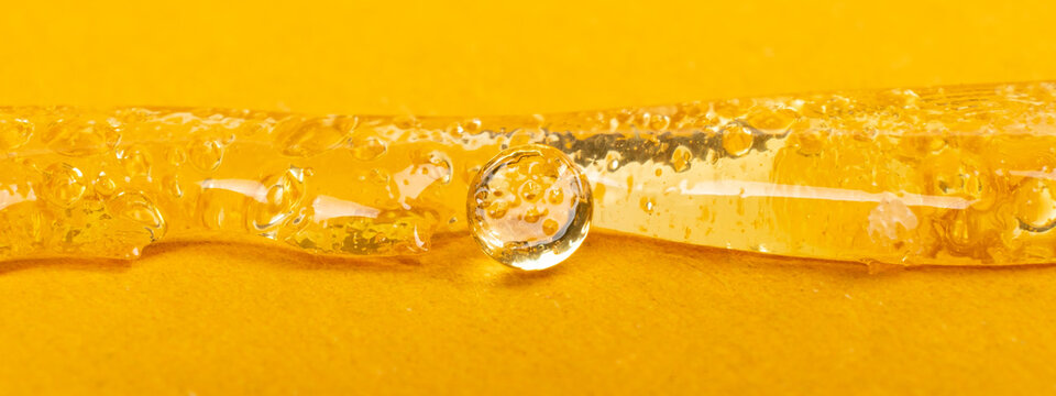 pure clear marijuana wax on yellow background, cannabis dab texture