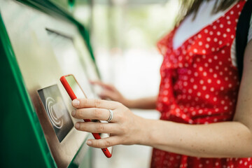 Young woman paying with mobile phone app for the public transport - Tourist making contactless...