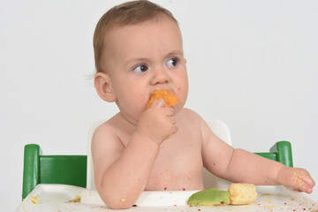 close-up of a child eating orange fruit on white background