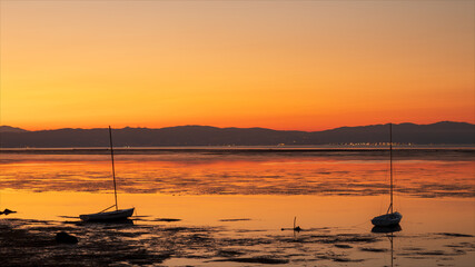 Barche a vela, ormeggiate al mare nella laguna dell'isola di Grado. Colorata alba.