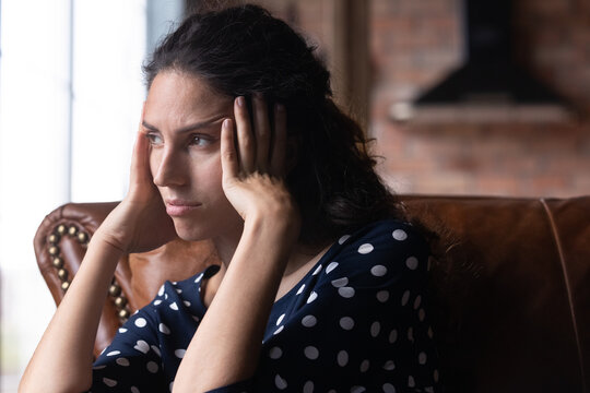 Bored depressed woman feeling apathy, suffering from boredom, negative thoughts, headache, fatigue, holding head, looking away, thinking over problems, bad news, loneliness. Frustration concept