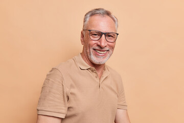 Happy grandpa senior man with grey hair and beard smiles toothily shows perfect white teeth wears...