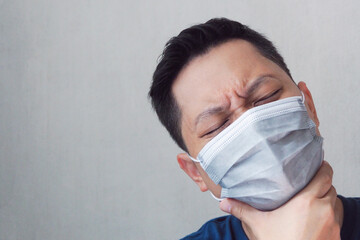 Asian man wearing face mask feeling sick at home Medical and human healthcare concept