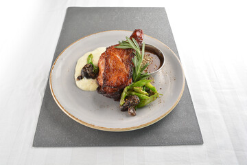 Texas grilled chicken leg confit with vegetables, mash potato and chef brown sauce in white background western main course menu