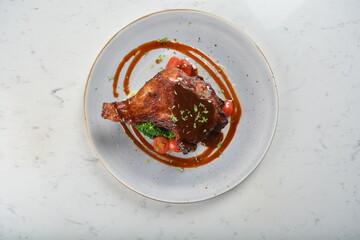 Texas grilled chicken leg confit with vegetables, mash potato and chef brown sauce in white background western main course menu