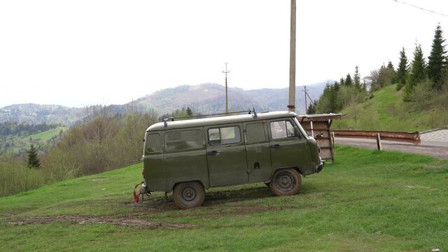 Ukraine. Carpathians. May 2021. Travel difficulties in the mountains. Towing a car stuck on a hill of clay and wet grass.