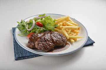 bbq grilled juicy wagyu beef tenderloin sirloin steak in brown black pepper sauce with French fries and vegetables salad dressing western cuisine menu