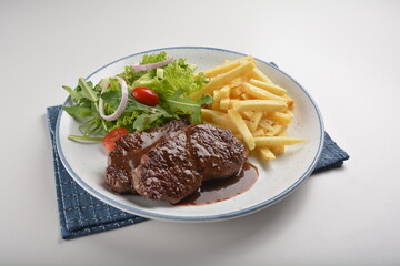 bbq grilled juicy wagyu beef tenderloin sirloin steak in brown black pepper sauce with French fries and vegetables salad dressing western cuisine menu
