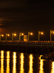 red night sky and lampposts lined up with orange lights reflected in the river in yellow beautiful atmosphere and is a tourist attraction of Thailand