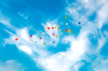 Colored flying balloons with greeting cards against blue sky background. Concept of happiness and joy, for banner, poster