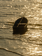 boat at sea beautiful small waves of water sunset reflecting water