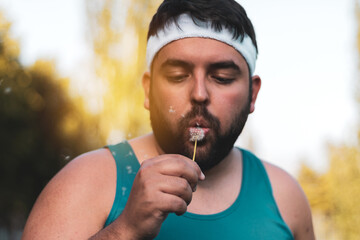 a fat boy blowing a dandelion