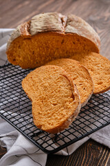 Closeup view of artisan whole grain tomato wheat bread cut on slices on kitchen table