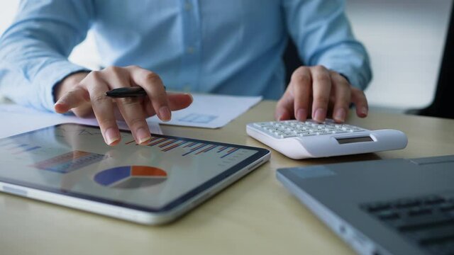 slow motion scene of accountant man using calculating on calculator to summarize or consider on statistic report at home office for business and financial concept	