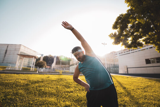a fat boy warming up before doing sports outdoors.
willpower.
determination.