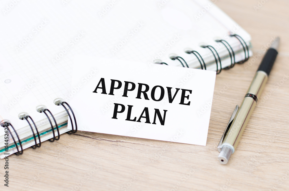 Poster white card with approve plan text on open notebook on table, business concept