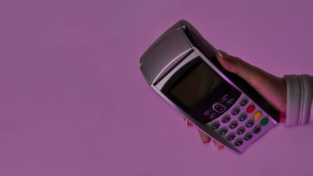 Hand with pin-pad. Payment via pos terminal. Bomerangs vertical video.