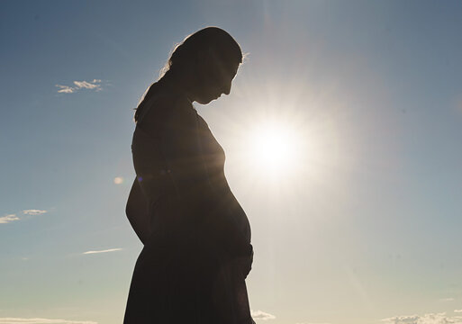 pregnancy photo silhouette of a woman blue sky