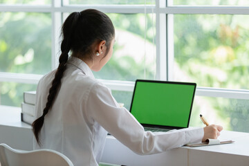 Back view of women using laptop computer blank green screen. chroma key monitor. businesswoman...