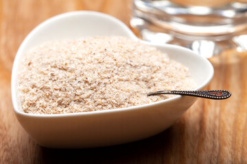 Close up of psyllium husk (ispagula) in a spoon. Psyllium husk, also called isabgol, is a fiber obtained from the seeds of the plantain ovate plant found in India. Selective focus.

