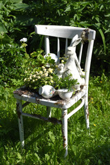 Vintage wooden chair with rabbit figurines in a garden