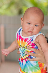 An Asian baby who was carried and looked at the camera. portrait of baby