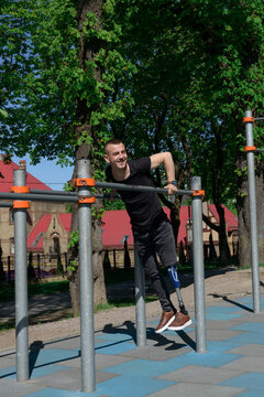 Athletic Young Man With Artificial Leg Working Out On A Bars