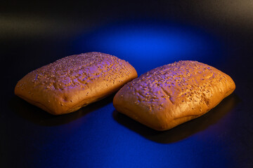 panini bun with sesame, sandwich. Without ingredients, on a black background. Bakery production concept.