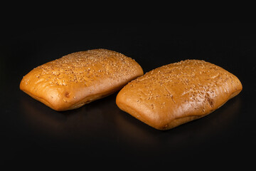 panini bun with sesame, sandwich. Without ingredients, on a black background. Bakery production concept.