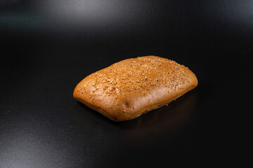 panini bun with sesame, sandwich. Without ingredients, on a black background. Bakery production concept. copy space