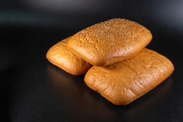 panini bun, sandwich. Without ingredients, on a black background. Bakery production concept. Copy space