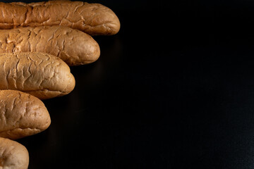 Hot dog bread, bun without ingredients. Concept for the production of baked goods for fast food. isolated on black background. Copy space.