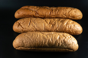 Hot dog bread, bun without ingredients. Concept for the production of baked goods for fast food. isolated on black background