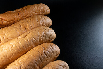 Hot dog bread, bun without ingredients. Concept for the production of baked goods for fast food. isolated on black background. Copy space.